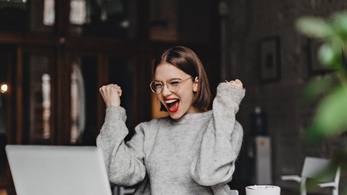 Woman cheering in front of her laptop